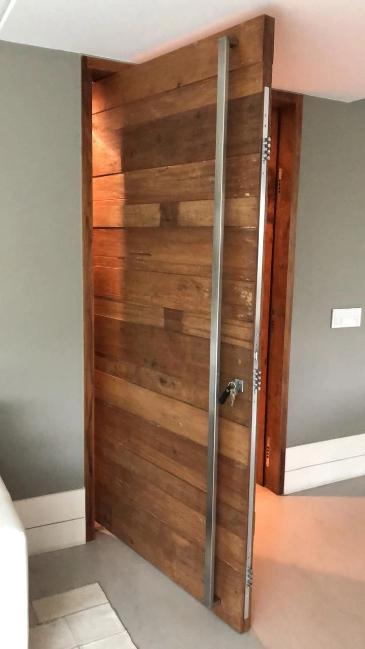 Porta de segurança com reforço em aço e acabamento em madeira maciça. Estrutura multiponto para alto nível de proteção com visual sofisticado e rústico.