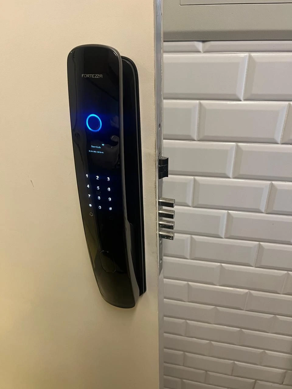 Fechadura digital Fortezza instalada com leitor biométrico e teclado numérico. Segurança moderna com tecnologia de ponta para casas e apartamentos.